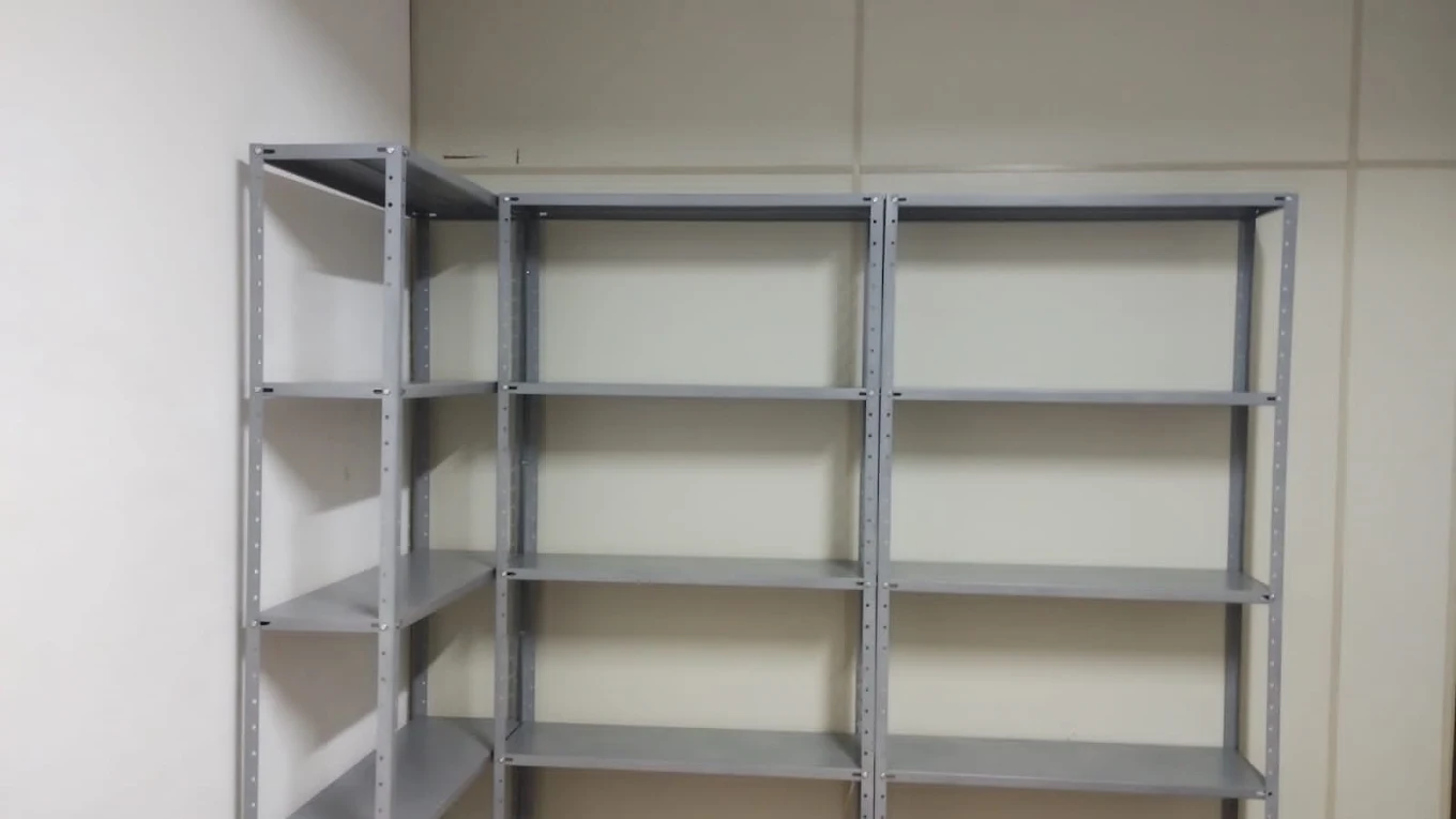 Estantes de aço com prateleiras montadas em canto de parede